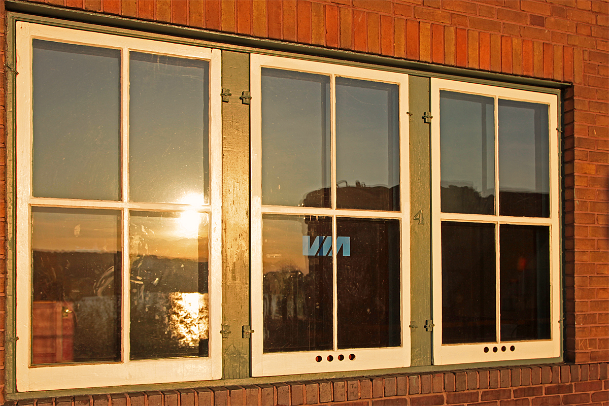 VIA doesn\'t serve Huntsville Staion anymore, hasn\'t for a long time. Sadly it will soon it will be the same with Ontario Northland. CN 4132\'s long hood reflects off the window pane as the sun sets on a spring day.