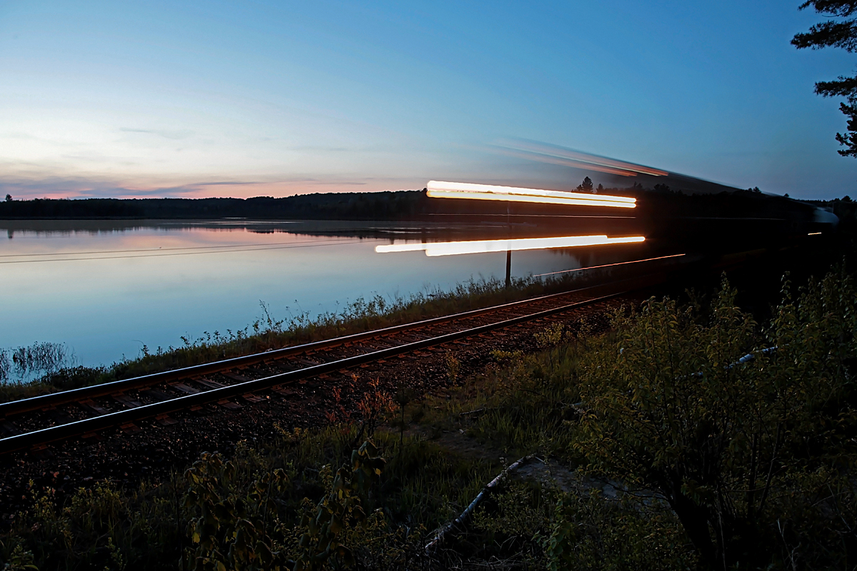 On my way home from town I heard CN 450 arriving at huntsville Yard. I decided to set up my camera on a tripod alongside Domtar Road looking over Siding Lake and wait for it. Thirty minutes later the sun had long set, so I took this 1-second exposure as it passed by.