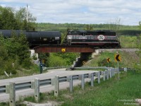 With the rolling hills of the Niagara Escarpment coming into view in the distance, CCGX GP9 1000, the sole power for the Orangeville-Brampton Railway shortline, heads north to Orangeville with a few cars from CP, crossing the bridge at Ferndale over the twisting Chinguacousy Road.