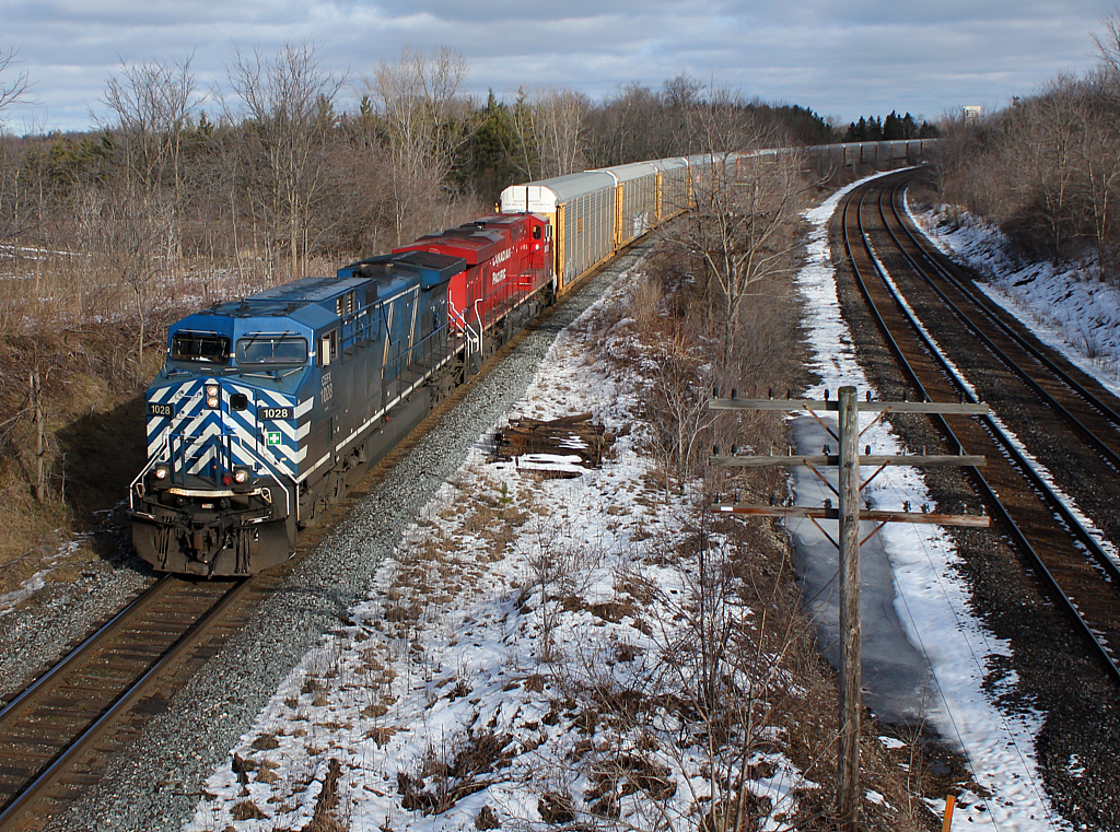 CP 147 with a bluebird leading, flies around the curve at the east end of Lobo.