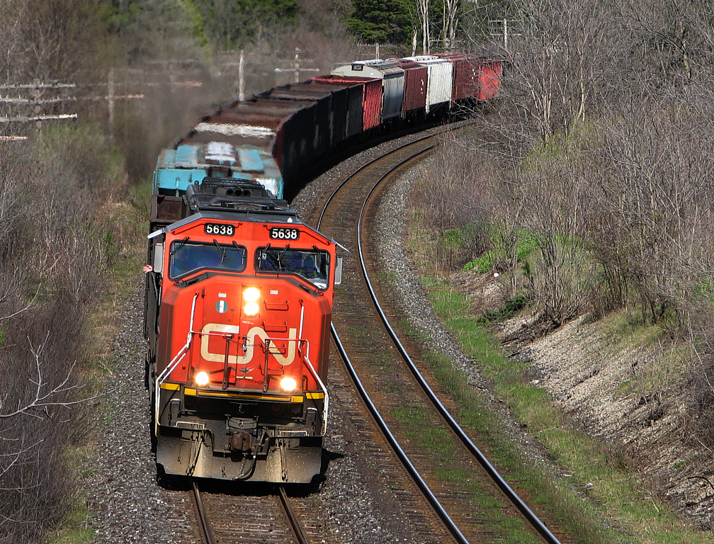 The engineer of 439 gives a wave as his train curves around the curve just east of Denfield Rd.
