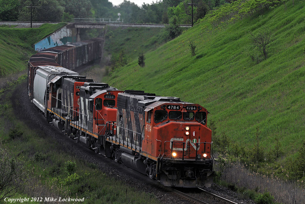 Struggling up the hill at Beare CN 4784, 4134, and 4710 are just now getting a handle on their train. Minutes before it looked like they\'d stall as 4710 was loading at 40amps and the leader was in the short time, however a second trip back by the conductor seemed to do the trick as they told the RTC they were getting 800amps out of her. This would have been to the releif of YB, as the only other option would have been to have 372\'s power cut off at McCowans and pull the stalled 570 back up the hill. 1825hrs.