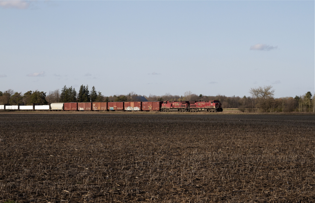 As another day comes towards a close a pair of GE AC4400CWs thunders across a field in rural Carlisle, Ontario.