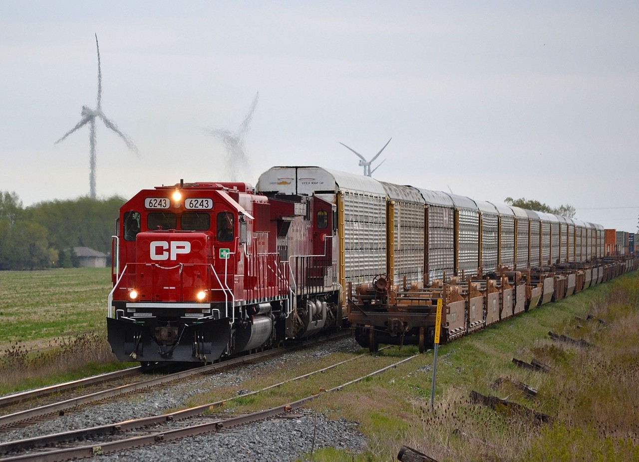 CP 141 led by freshly rebuilt 6243 (ex SOO 6043) heads westbound and passes by a cut of empty intermodal cars sitting in the setoff siding at St Joachim.
