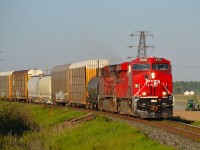 CP 441 led by brand new 9372, rounds the bend into Tilbury as a farmer works in his field in the background.