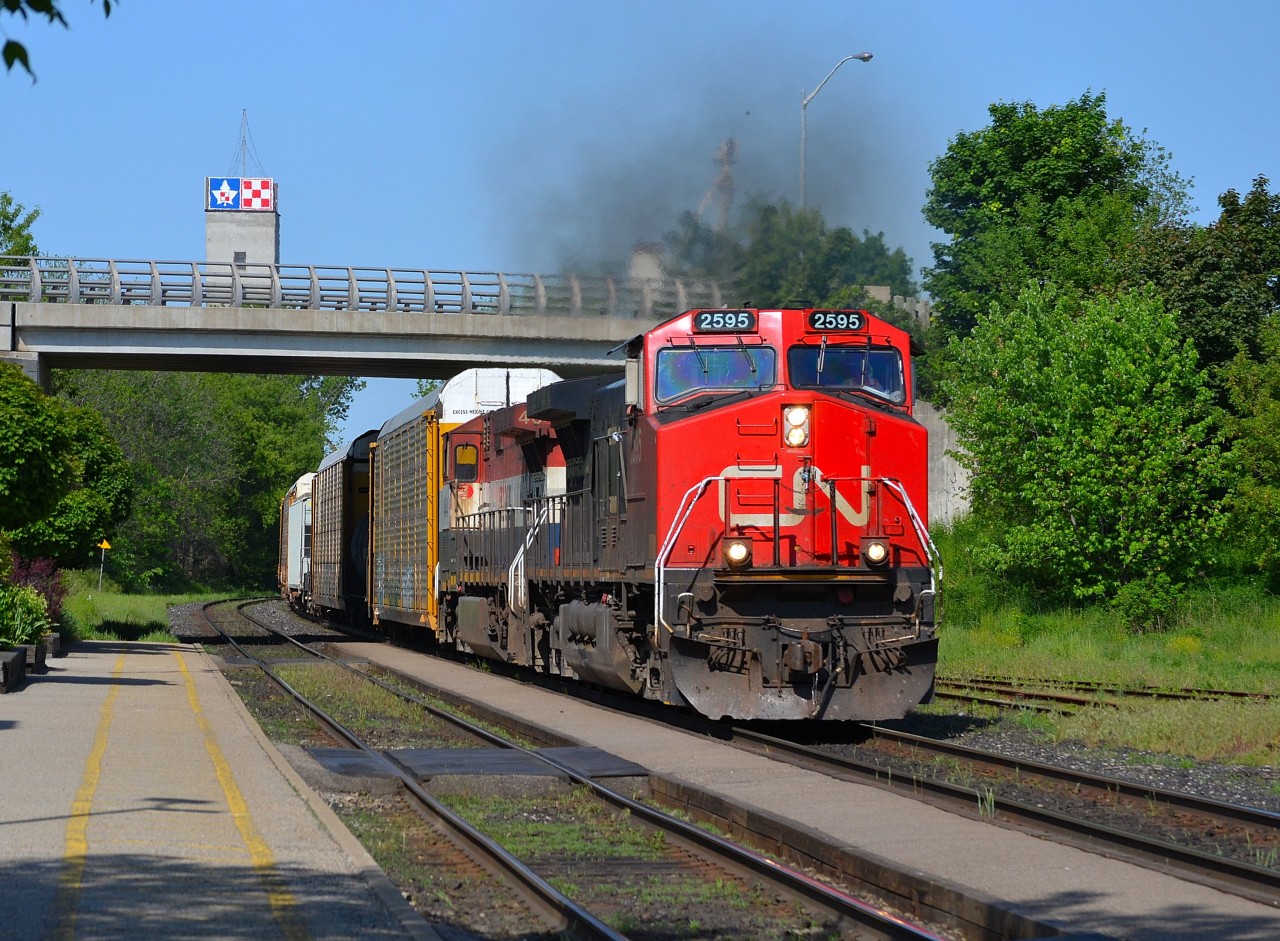 CN 148 with a CN/BCOL combo for power, rounds the bend at the Woodstock VIA station and heads eastbound.