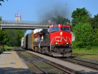 CN 148 with a CN/BCOL combo for power, rounds the bend at the Woodstock VIA station and heads eastbound.