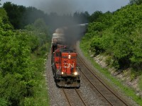 CN 7054 heads West towards Windsor, with CN train 539. The GP9 was pouring on the Smoke getting out of London with its long train.