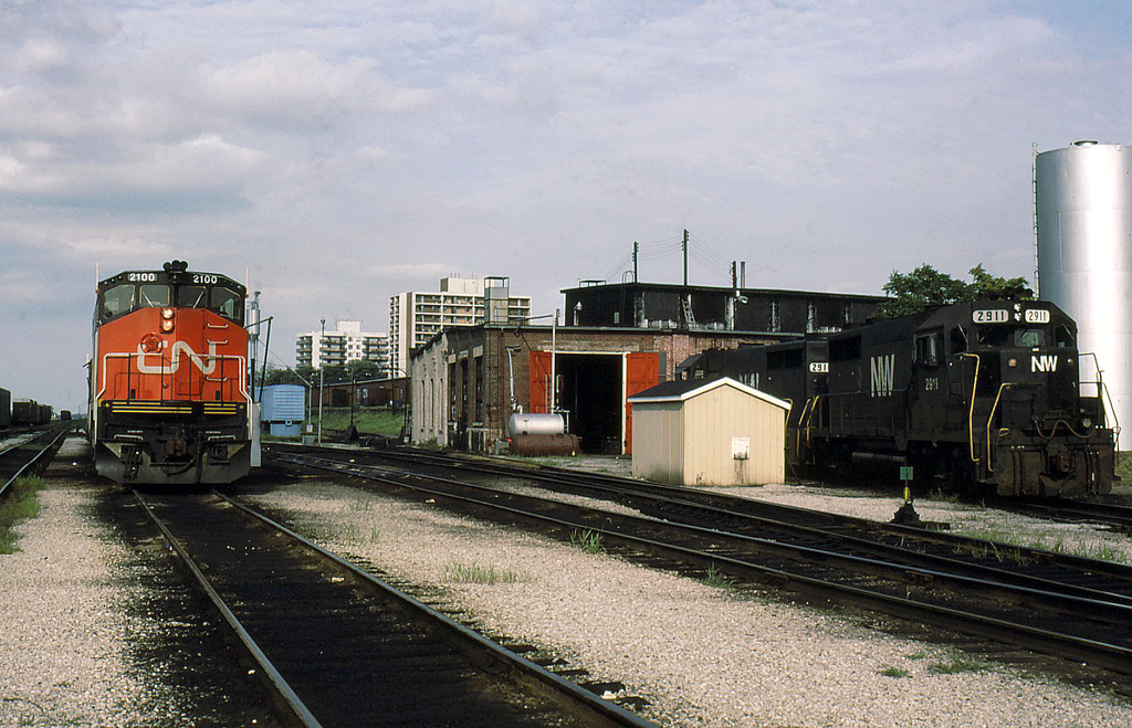 Almost new CN 2100 waits for an assignment while the NWs seem to be calling at the small shop for a job.