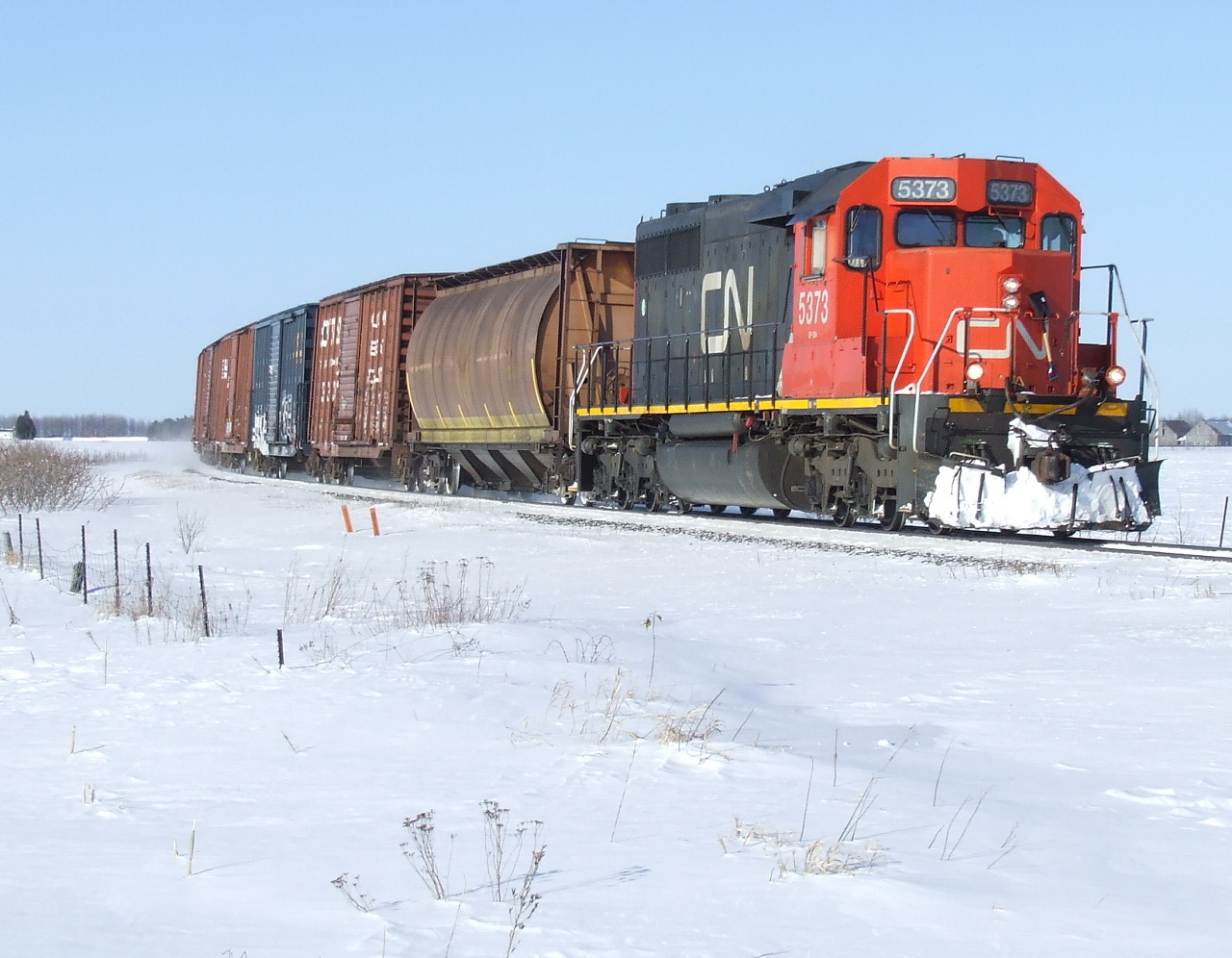 CN 514 rounds the curve with a dozen cars and a former UP sd rebuilt by CN PSC shop in1994.