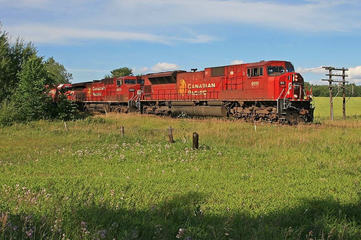 A southbound CP manifest with a \"90MAC\" in the lead position prepares to take the siding at Craighurst for a meet with northbound priority intermodal traffic.