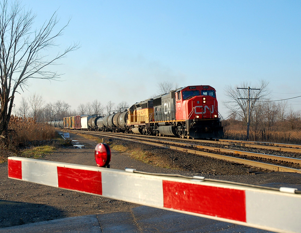 What I believe is CN 390 makes it's way past the crossing at Powerline Road with CN 5711 - UP 3331 and 73 cars