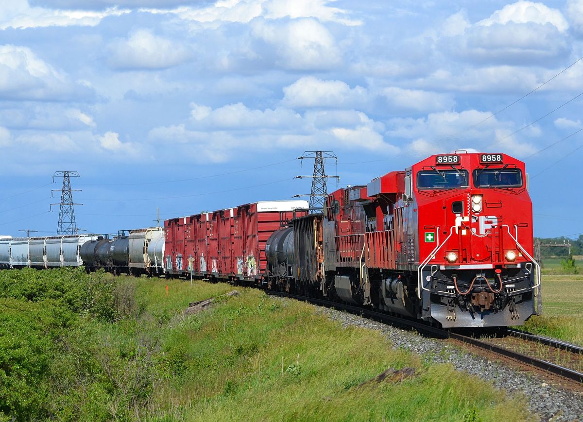 With threatening clouds looming in the background, CP 441 led by brand new 8958 rounds the bend thru Tilbury heading westbound towards Windsor.