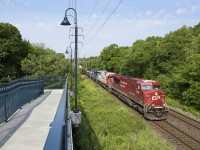 On a humid June morning, CP 8726, along with SOO 6024, ICE 6102 (ex-IMRL), and ICE 6416 "City of Linwood" lead a moderately sized eastbound past MacLennan pedestrian bridge.