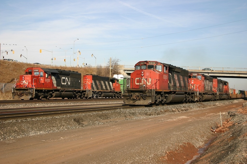 CN 383 blasts by on the main as CN 393 works Aldershot Yard.