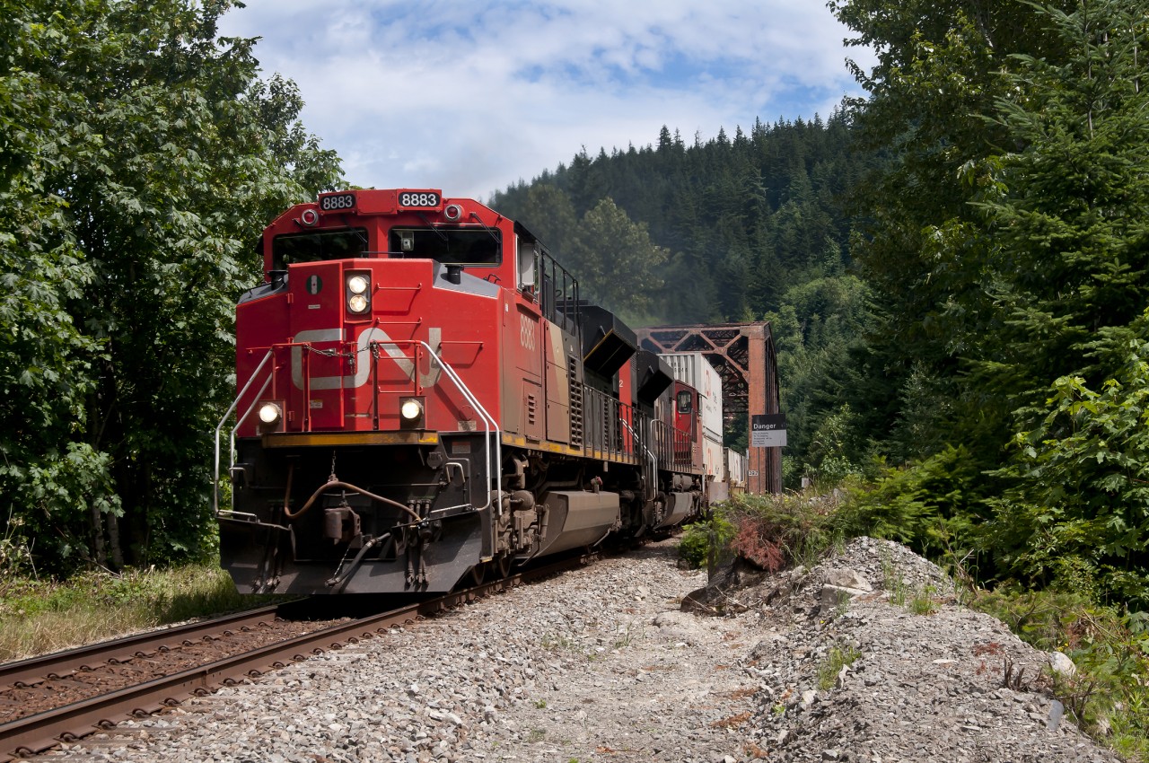 CN  8883 cruises along the southern boundaries of the town of Hope, BC.