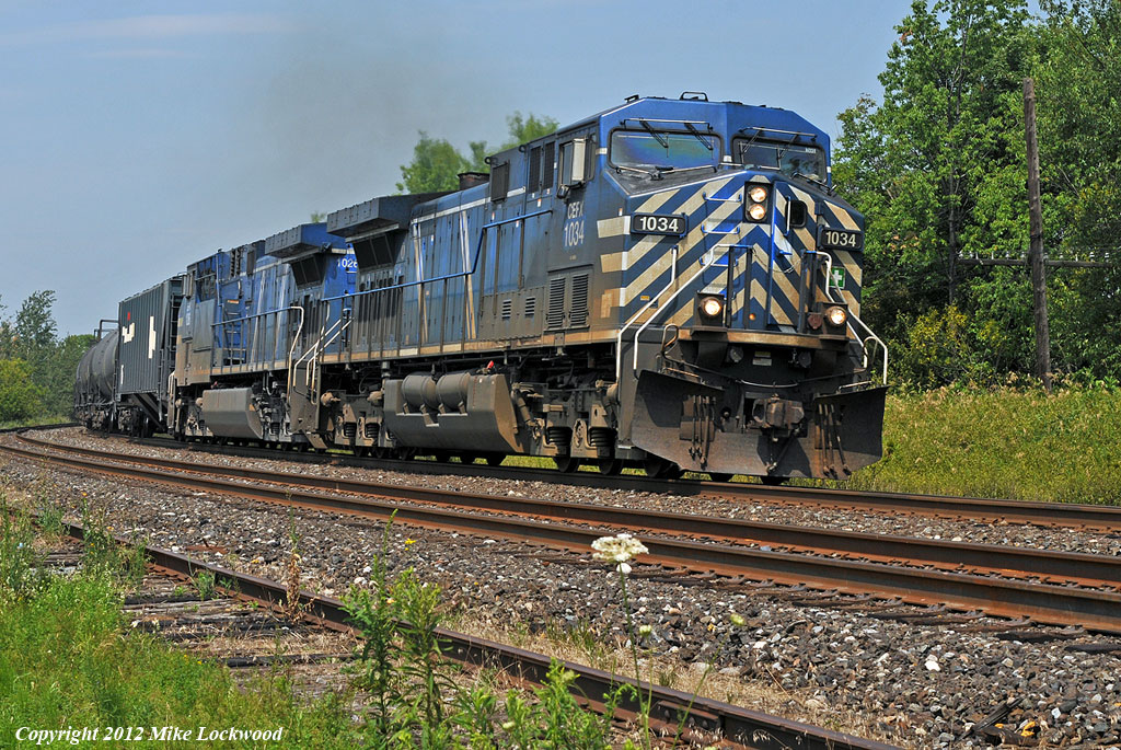 A pair of bluebirds, CEFX 1034 and 1026 wheel 608's train east through Lovekin, Ontario. 1232hrs.