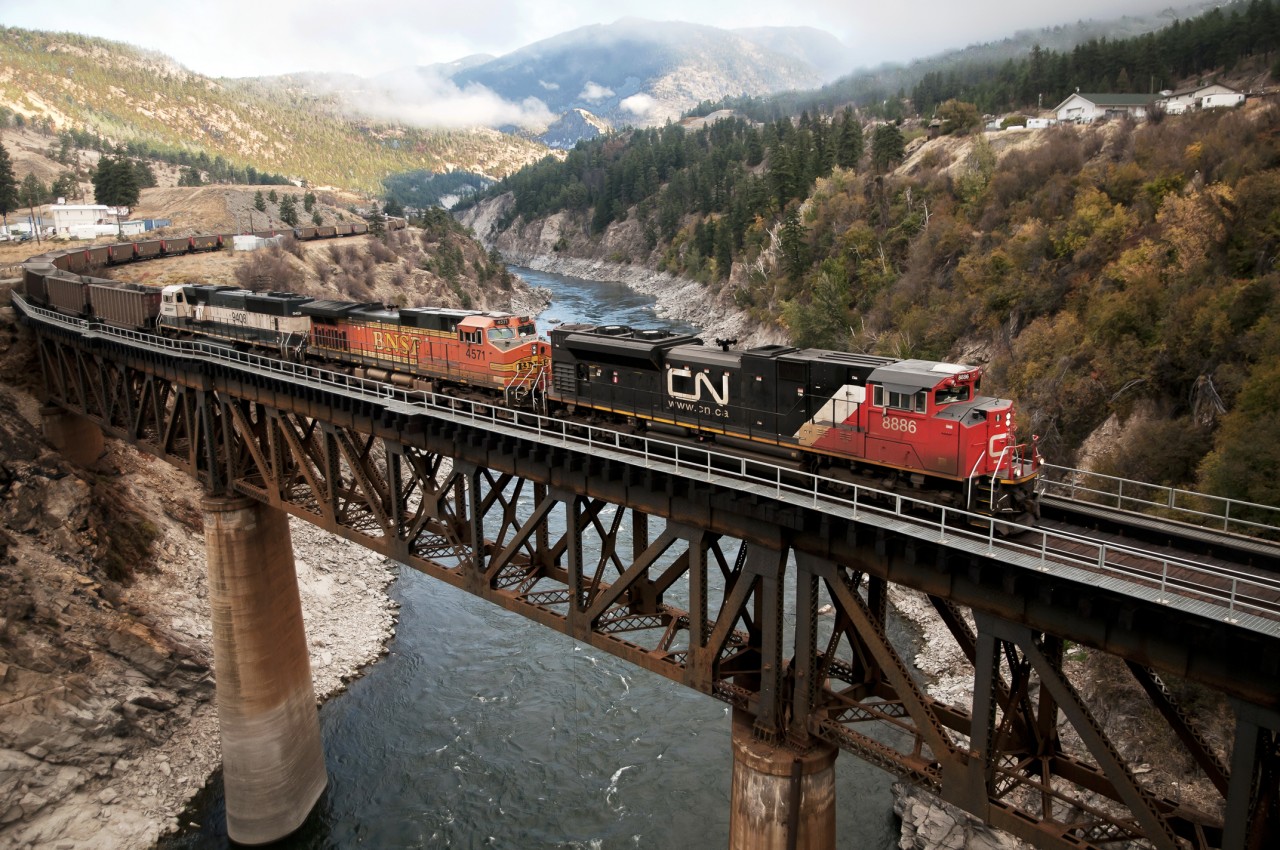 CN 8886 leads a Powder River Basin coal empty over what many call the "wheel chair accessible bridge" at Lytton.  The early morning sun has yet to burn off the low lying clouds.