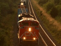 CN 372 emerges from the setting sun with tonnage for Montreal after being overtaken by VIA 650.