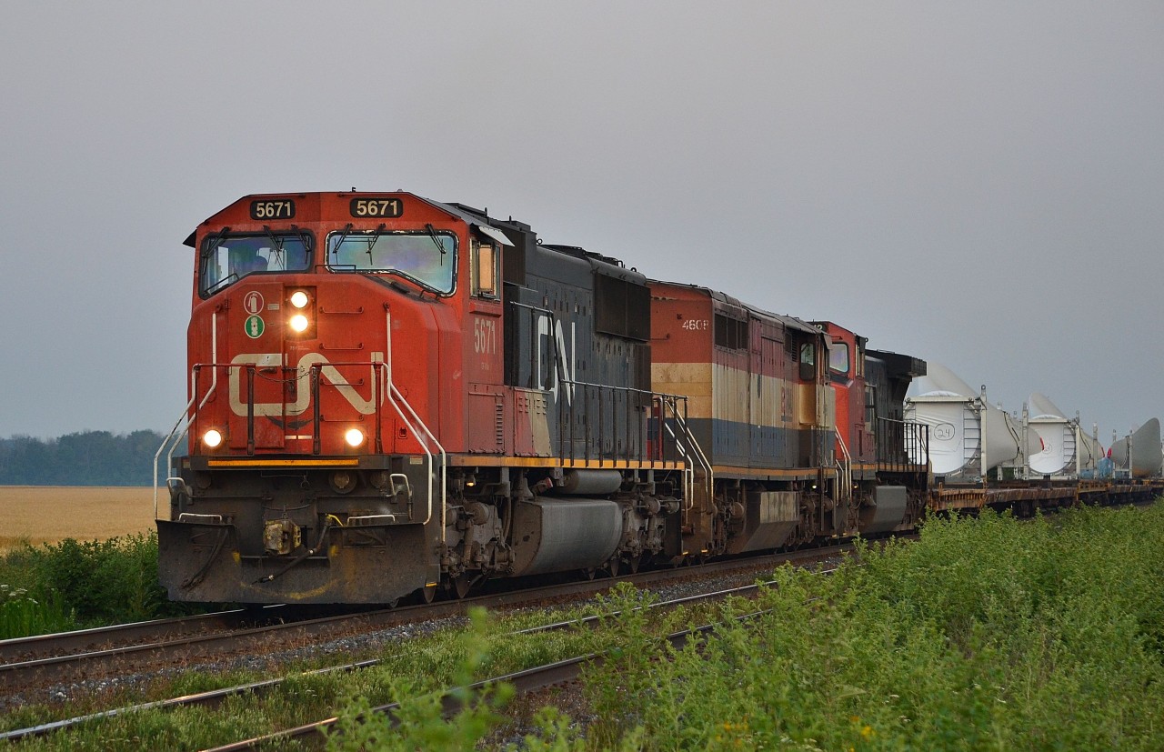 CN X330 heads east out of Sarnia in the early morning haze with this long load of windmill blades.