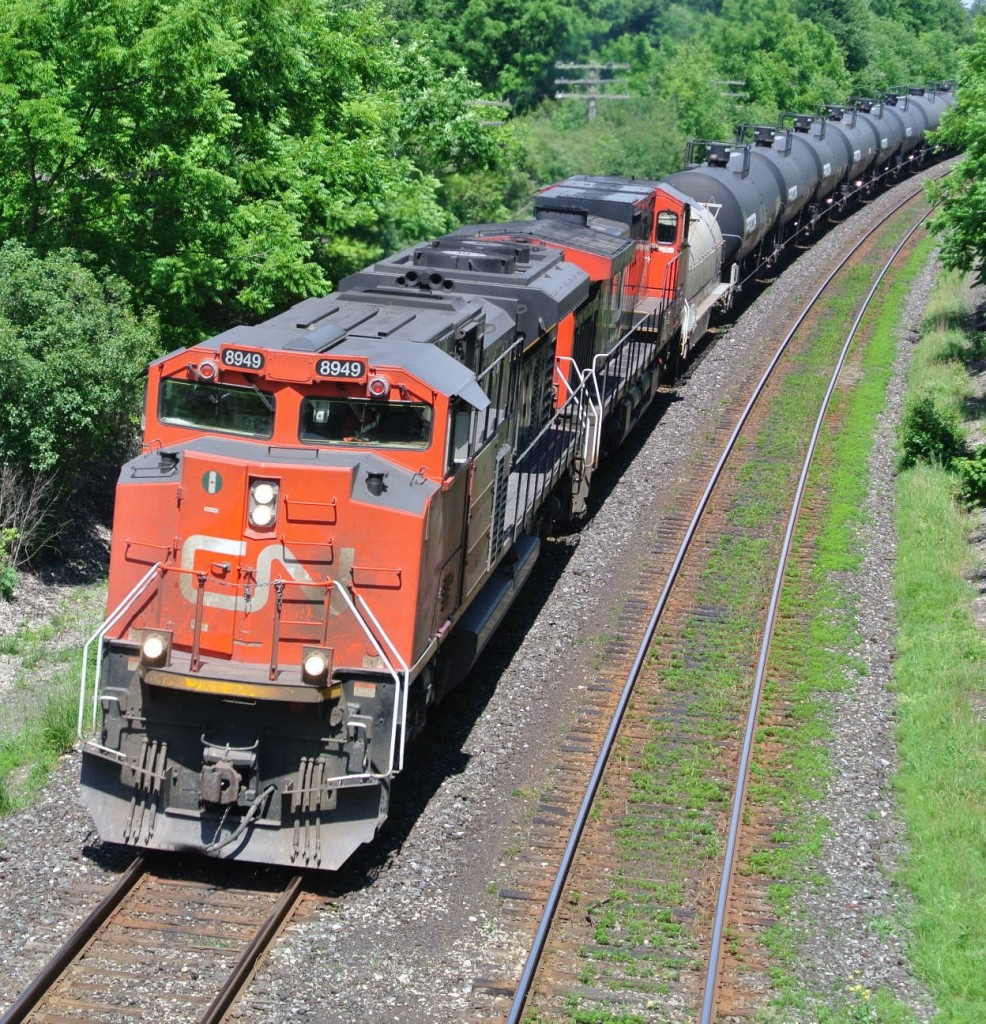 Cn 8949 rounds the bend out of london with a coil car leading a string of tankers
