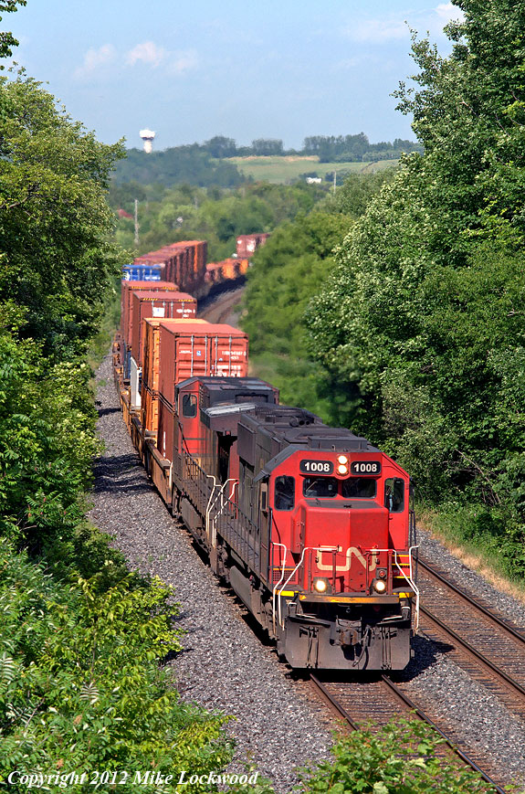 IC1008 and CN 2624 grind upgrade out of Port Hope with a typically long train 149 at Wesleyville, Ontario. 1634hrs.