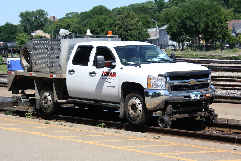 A Loram High Rail Truck cruises by on the South Track at Brantford Ontario.  It and a CN truck were inspecting the Dundas Subdivision.  The Loram truck was from Minnesota as noted by the license plate.  With one of these trucks checking the tracks it means that a grinding train may be crossing these rails in the near future.  They had to make it to CN Masseys before Via 72 and CN 332 reached the station.
