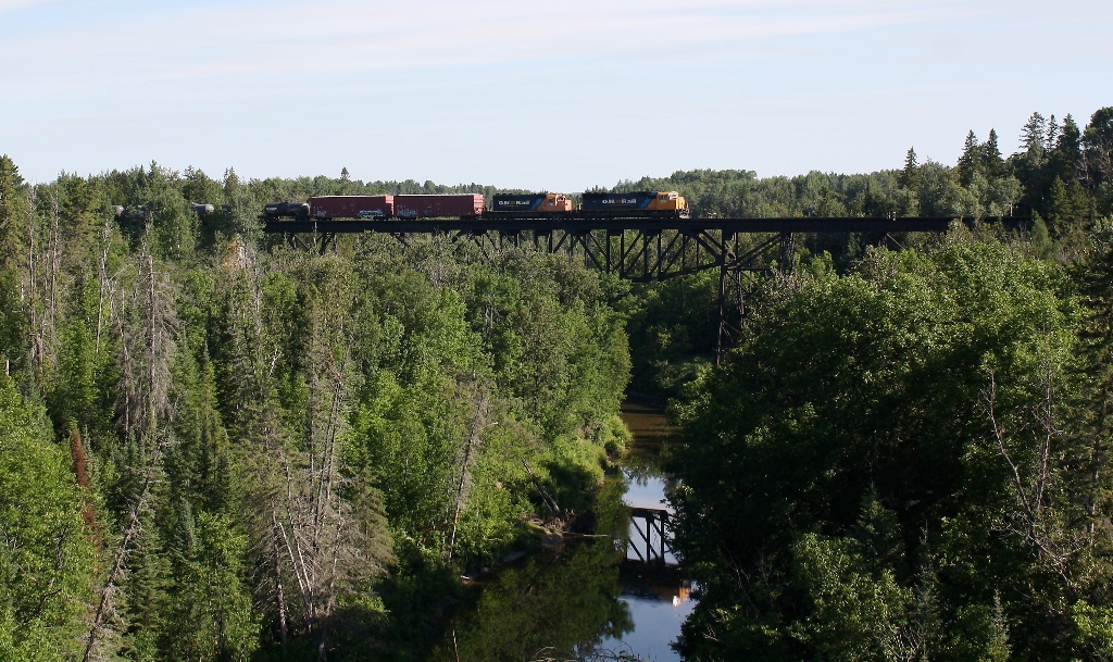 ONT 2103 leads train 214 across the Englehart River just South of the town of Englehart on the ONR Temagami Subdivision