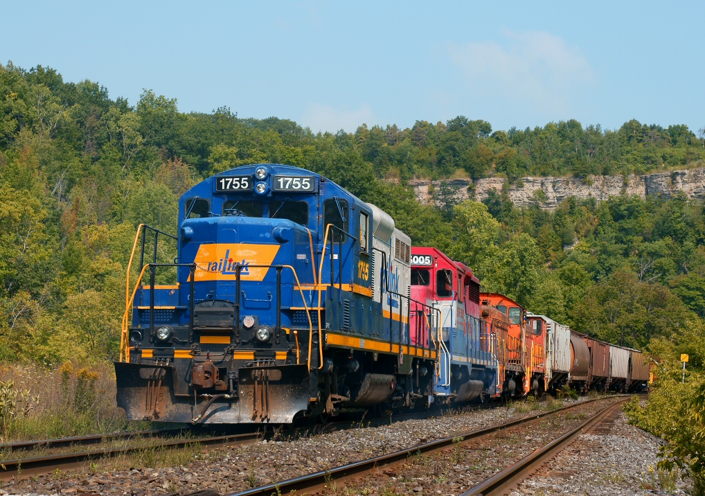 A pair of RLK units along with a pair of Stelco switchers tag along for the ride on CN-SOR's joint bottle train, as the train moves east through Dundas, Ontario.