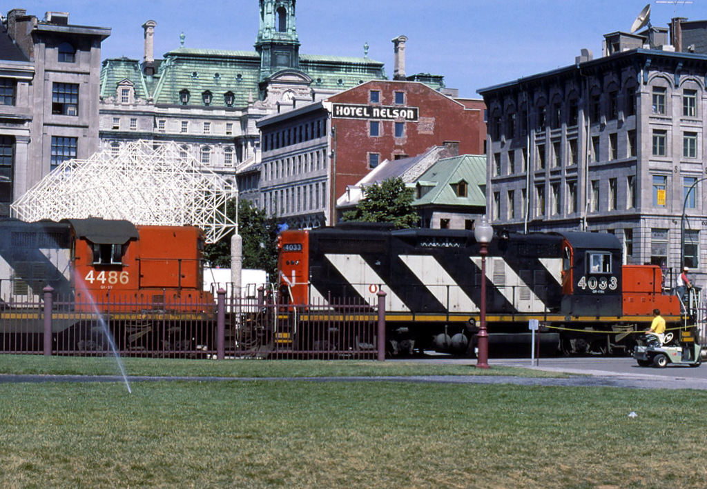 CN 4033 moves slowly past  Pl Jacques Cartier on its way to the harbor with its containers.
