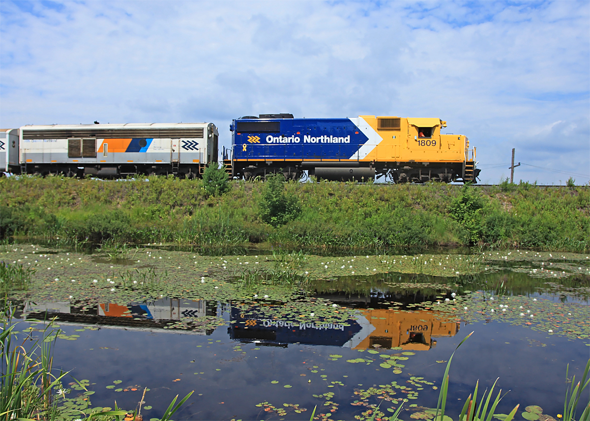 Ontario Northland 1809 makes a pretty reflection in a pond just south of Martins, 2012-07-15