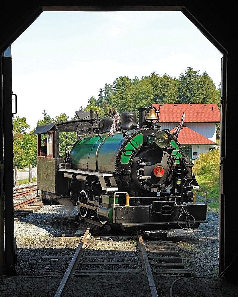 Taking a spin on the little homemade turntable at the west end of the line with the Rotary Village Station in the background, as seeen from inside the train shed. The turntable is constructed with the rails mounted on a thick steel plate bolted to the swing bearing off an old Cat excavator which in turn is mounted on a 6-foot deep concrete base.