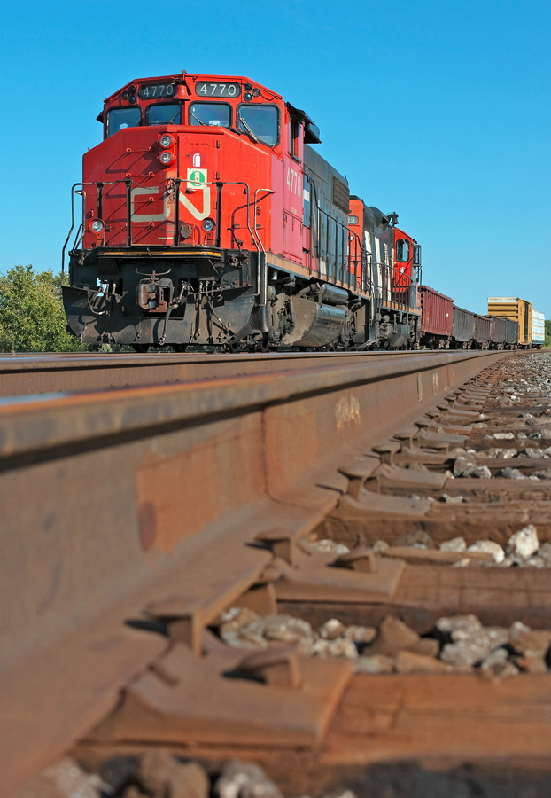 A pair of GP's sit on the south track between Tansley and Ash awaiting the arrival of CN 399, today's train consists of 5 empty scrap gons for Triple Metals and 2 loads of lumber for Tamarack Lumber.
