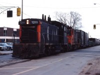 CN 1211 and CN 1227 take train 535 down Ferguson Avenue in Hamilton on a dreary December day in 1975