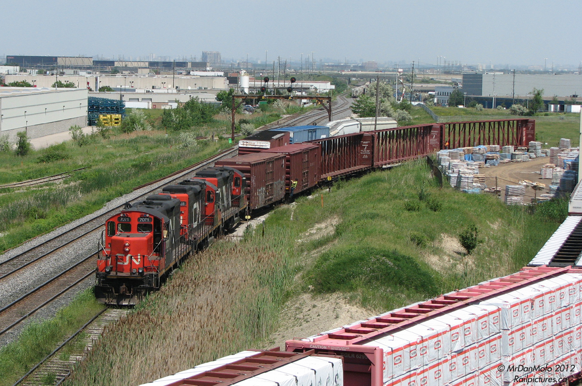 Today's CN #559 is working the local Brampton industries with not the usual two, but three rebuilt GP9RM's. With the trainee conductor riding one of the boxcars and another crew member further back, units 7071, 7068 and 4112 pull some centrebeams out of CanWel Building Materials' distribution centre off West Drive.