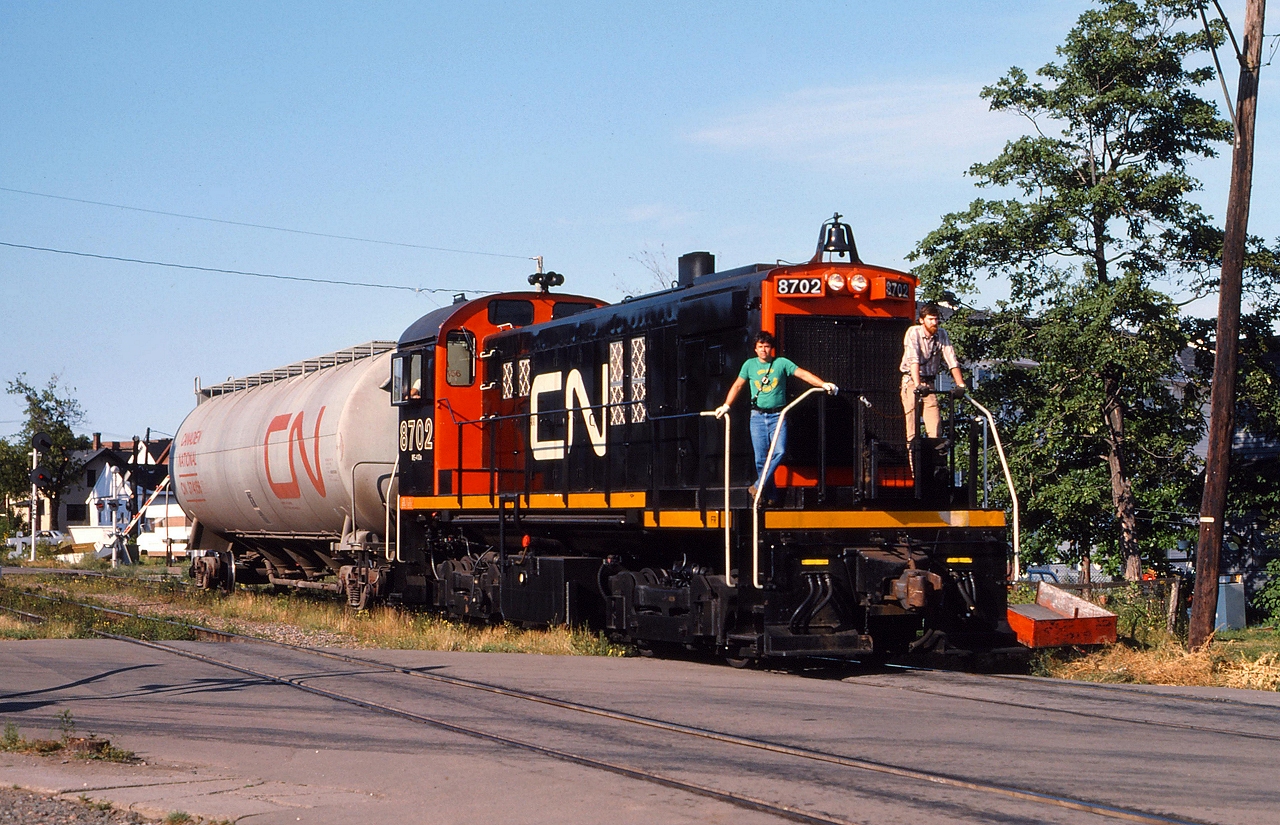 Freshly painted CN 8702 rolls through downtown Moncton with a single car