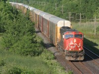 A lone CN SD75i leads westbound racks (possibly CN 332) on a pleasant early summer evening.