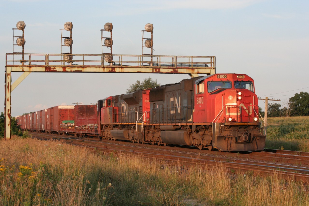 A westbound CN mixed freight roars towards Nith Road at Paris West on a beautiful summer evening. Note the missing number locomotive number board over the right cab window.