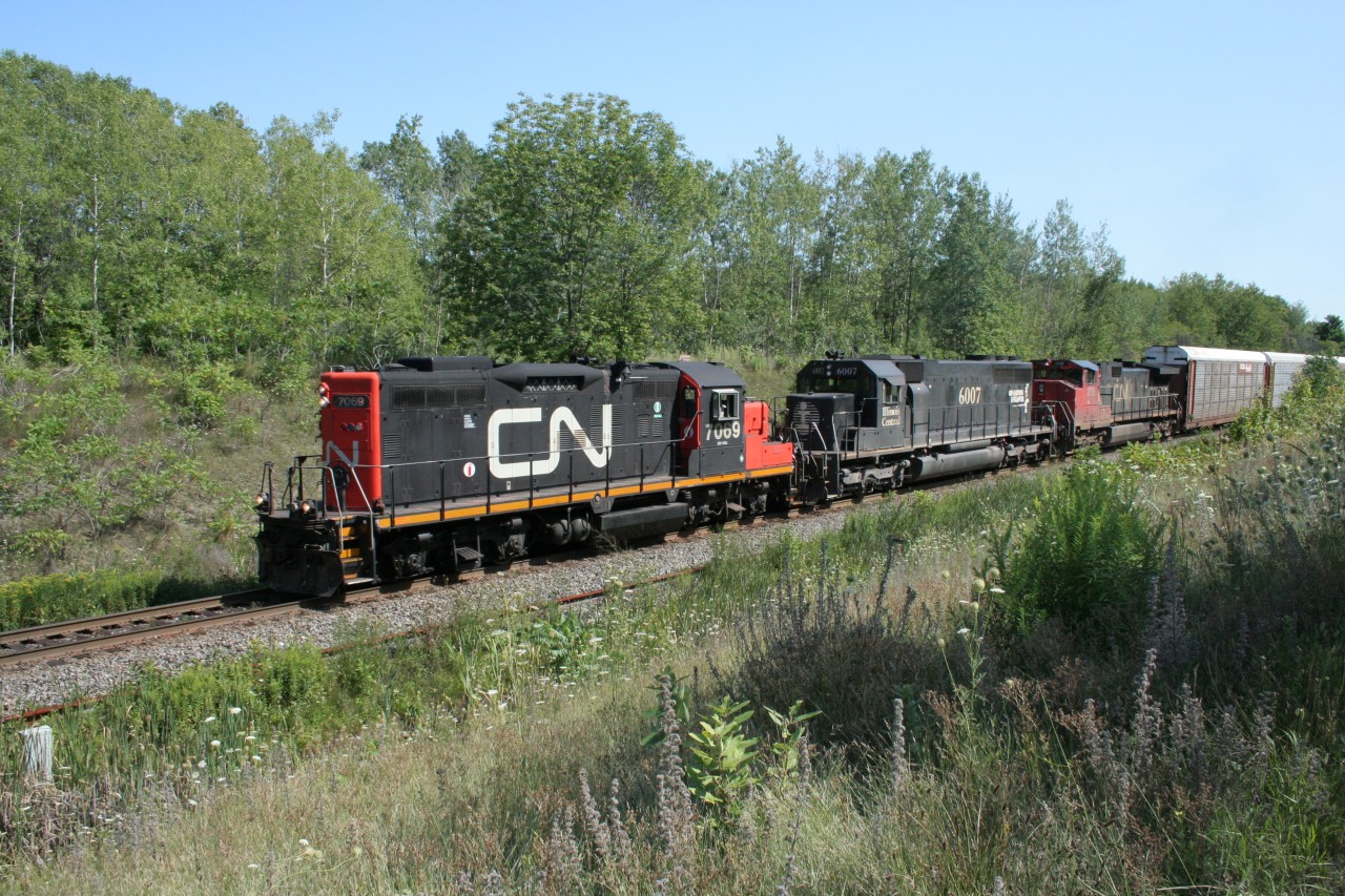 Running long-hood forward, CN geep 7069 leads an eastbound manifest towards MacMillan Yard. It's interesting to see a GP9 lead two six-axle units.