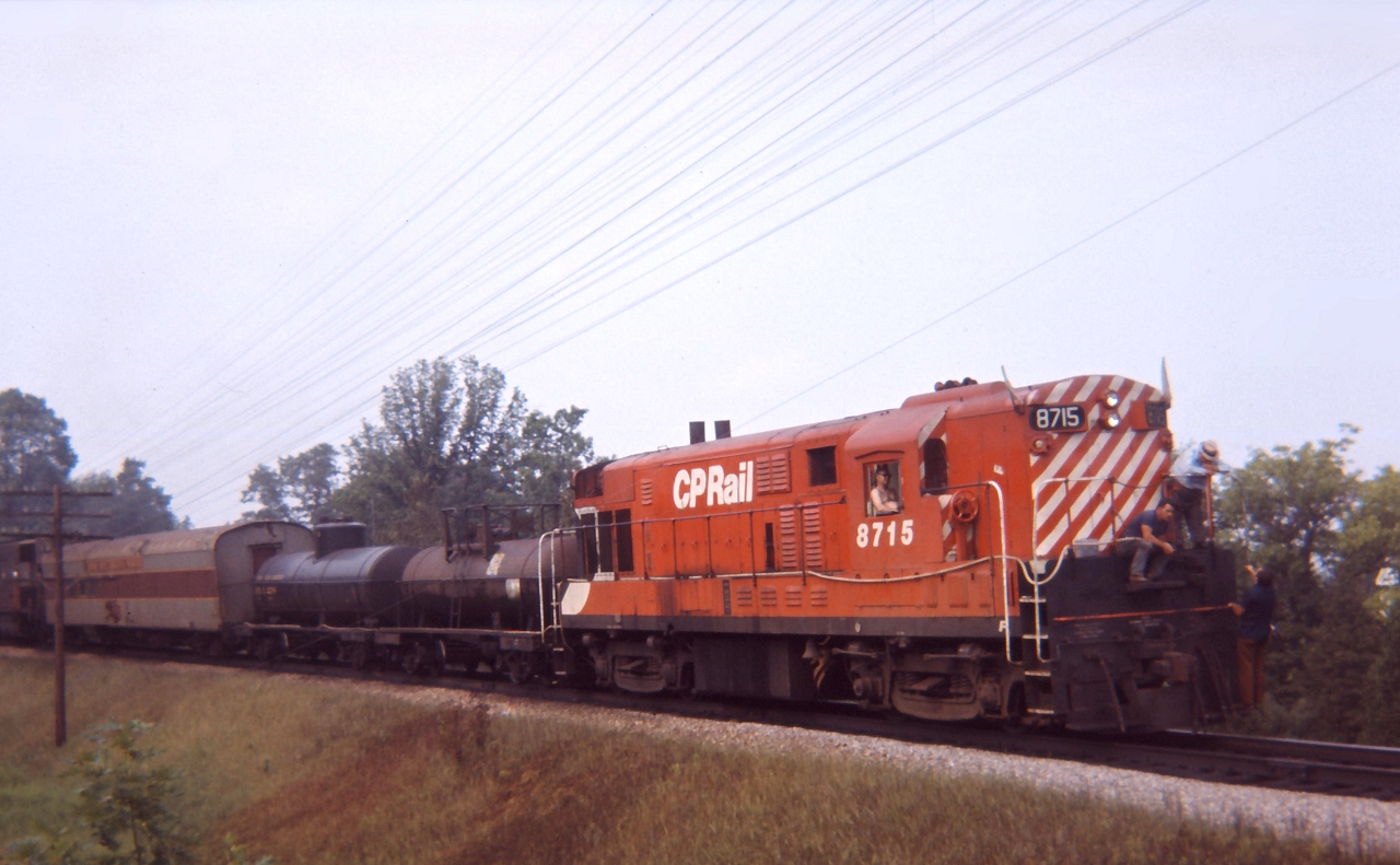 H16-44 8715 leads a rail grinding train downgrade between Orrs Lake and Galt, employees on the front a wetting the right of way to prevent any brush fires.