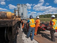 After being called for as a conductor on a  L351 this morning out of MacMillian Yard, I decided sure, why not, I'll being the camera with me. Turns out we had to take a D1R transformer 42 miles where it was to be off loaded onto truck then taken the rest of the way to the hydro substation just down the road off of Tremaine Rd in Oakville. Here crews from Don Anderson are using hydraulic jacks (not seen) to push the transformer from flat car to flat bed as workmen watch on. 