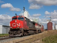 CN 115 passes a track gang parked back in the elevator siding as it goes through Three Hills towards Calgary. CN 2544 with BC Rail 4605.