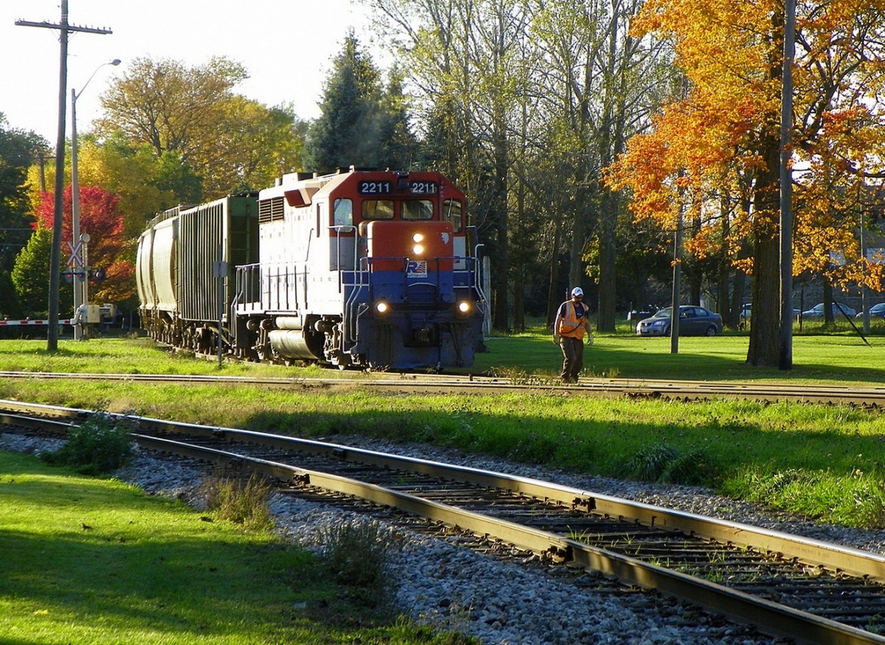 RLK (GP35)2211 eb mixed arr Stratford ON off Goderich Sub.  Fall colours, 6pm, pauses as RA employee tends to 'opening the gate' - 133mm.
