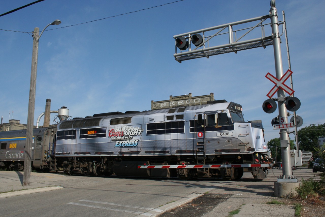 VIA 084 with VIA 6408 done up with Coors Light decals departs the Kitchener VIA Station bound for Toronto. Note that this scene has changed. It is now the location of the platform for GO train commuters.