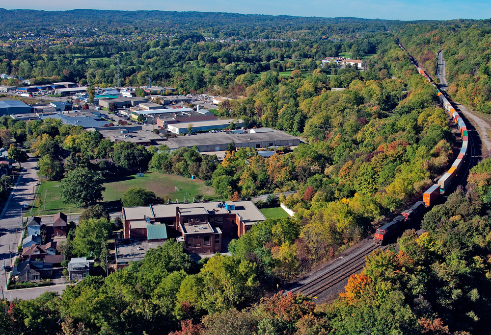 Fall is in the air as the tree leaves begin to change into different shades of colour, a pair of GE's hold back 9,676 ft of train 148 for Brampton Intermodal.