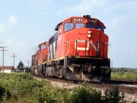 CN 305 rounds the curve wuith horn blaring for the coming crossing .