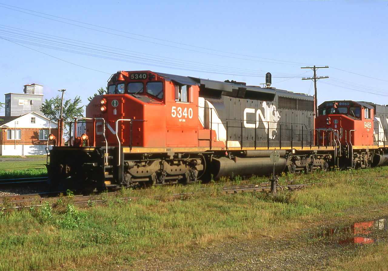 CN 305 waits in the siding with 5340 sporting the latest paint scheme.