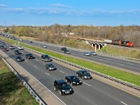  	  Drivers along the 403 go on about their daily routine in the afternoon rush hour, a pair of GP's drag out CN 435's set off to sort out in the lower yard. 