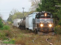 Having just come down the Owen Sound Spur from Orangeville on the left, the engineer peers out of the cab of CCGX 1000 as the biweekly Orangeville Brampton Railway local backs their train of interchange cars into the siding at Streetsville for CP to lift. Upon making the setoff, the crew will run their high-nose GP9 around to the north end, lift the 5 covered hoppers CP set off, and head back up the line homeward.
