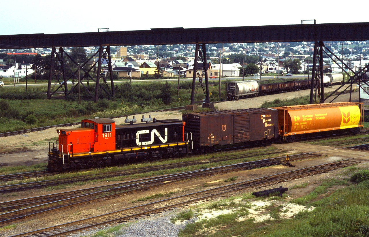CN 1911 shuffles a CP grain box and a new Government of Canada grain hopper around at Thunder Bay North